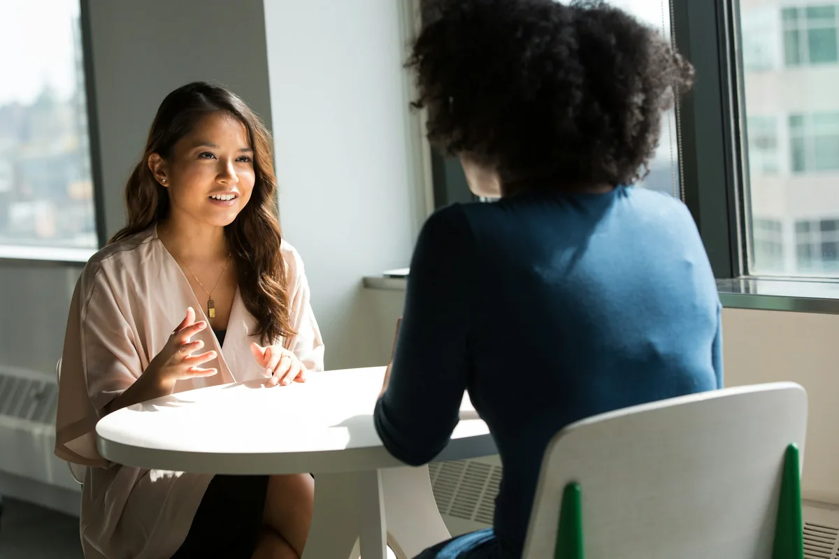 Duas mulheres conversando com calma à mesa, como no início do acompanhamento psicológico